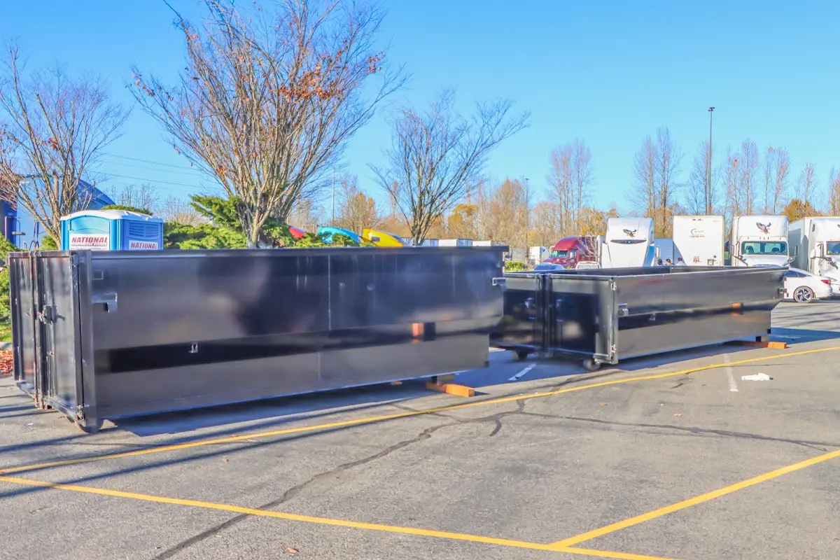 Professional dumpster rental service with roll-off container on residential driveway in Oronoko